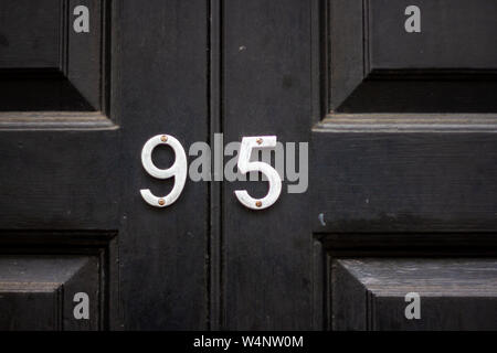 Haus Nummer 95 auf einem schwarzen aus Holz geschnitzte und getäfelten Tür Stockfoto