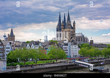 Köln, Deutschland - 12. Mai: Touristen am Rhein in Köln, Deutschland, am 12. Mai 2019. Blick auf den Kölner Dom und große Sain Martin Kirche. Stockfoto