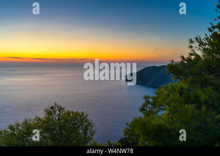 Griechenland, Zakynthos, endlosen stillen Ozeans und Cliff hinter grünen Bäumen, in der blauen Stunde Stockfoto