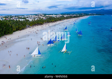 Menschenmassen versammeln sich am weißen Strand von Boracay Island, um den Sonnenuntergang zu beobachten. Stockfoto