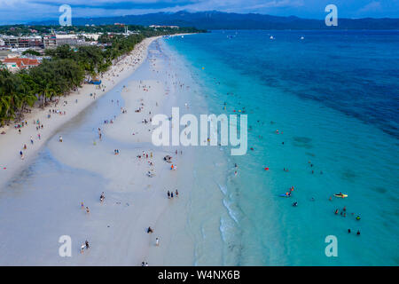 Menschenmassen versammeln sich am weißen Strand von Boracay Island, um den Sonnenuntergang zu beobachten. Stockfoto