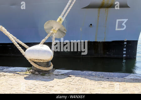Varna, Bulgarien, 20. Juli 2019. Große graue moderne Kriegsschiff angelegt am Meer port Poller mit dicken und haltbare Seile an einem sonnigen Sommertag. Stockfoto