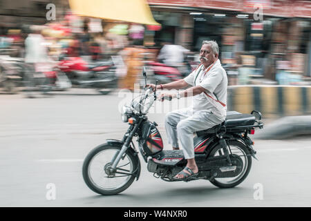 Ein Inder sein Moped auf der Straße. Stockfoto