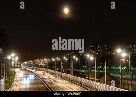 Der Mond über der beleuchteten Autobahn und die Nacht Stadt, Stockfoto