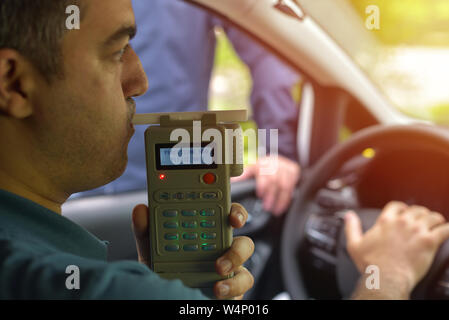 Treiber an, da der Betreff für Alkoholgehalt mit Verwendung von breathalyser zu testen Stockfoto