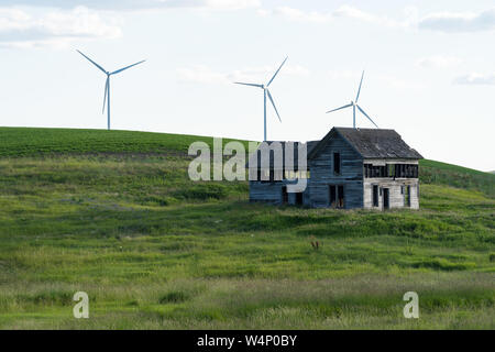 Spooky, alten, verlassenen Bauernhof in den sanften Hügeln des Palouse im Staat Washington. Windmühlen im Hintergrund Stockfoto