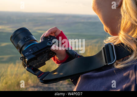 Colfax, Washington - Juli 3, 2019: Junge Frau Fotograf zeigt Ihr Sony A6500Spiegellosen SLR-Kamera, mit der Einstellung "Auto". Konzept für neue photog Stockfoto