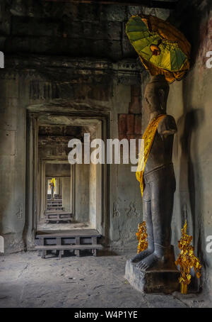 Angkor Tempel, Siem Riep, Kambodscha - Februar 12, 2018: Flur mit einer Statue stand vor und am Ende des Korridors Stockfoto
