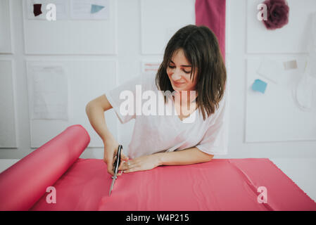 Fashion Designer schneiden ein Gewebe mit einer Schere. Stockfoto