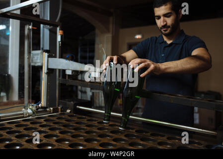 Fokussierte Keller Arbeiter mit Flaschen Sekt im Keller der Herstellung im Penedes region, Katalonien, Spanien Stockfoto