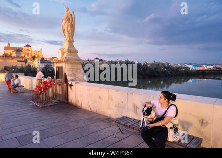 Auf der Römischen Brücke, ein kleiner Altar oft von Kerzen und Blumen umgeben, auf dem eine Statue von St. Raphael in Cordoba, Andalusien, Spanien Stockfoto