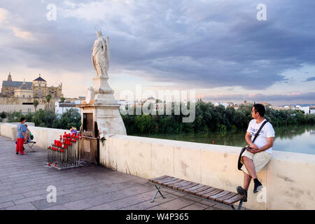 Auf der Römischen Brücke, ein kleiner Altar oft von Kerzen und Blumen umgeben, auf dem eine Statue von St. Raphael in Cordoba, Andalusien, Spanien Stockfoto