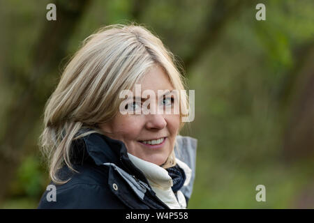 UK, Bunny Hill Top - April 2019: Portrait - blonde Frau mittleren Alters tragen Outdoor Kleidung, lächelt in die Kamera Stockfoto