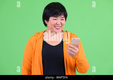 Junge glücklich Übergewicht asiatische Frau mit Telefon bereit für gym Stockfoto