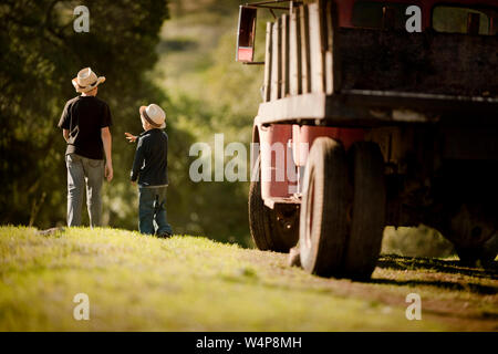 Zwei Jungen Spaziergang, vorbei an einem Bauernhof Pickup Truck. Stockfoto