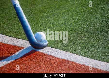 Hockey Stick und Ball auf gefälschtes Gras mit Platz kopieren. Stockfoto