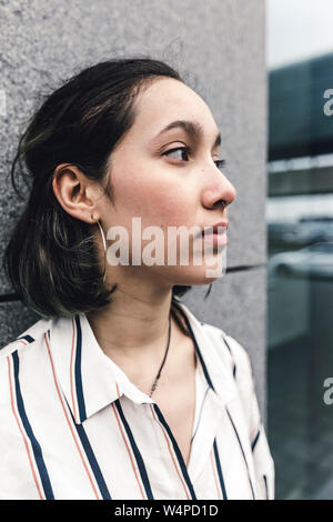 Traurige junge Frau wie ein Arbeiter steht lehnte sich an der Wand. Stadt im Freien. Stockfoto