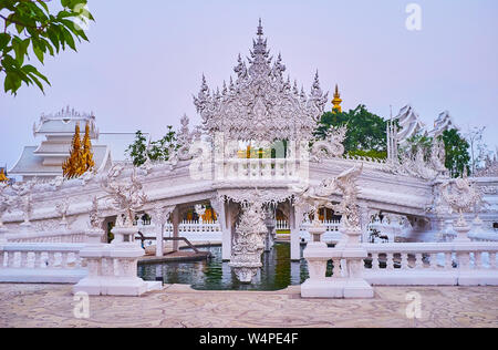 Die malerische Wiedergeburt Zyklus Brücke genießen und verzierten Tor des Himmels von Naga Schlange Skulpturen umgeben, weiße Tempel, Chiang Rai, Thailand Stockfoto