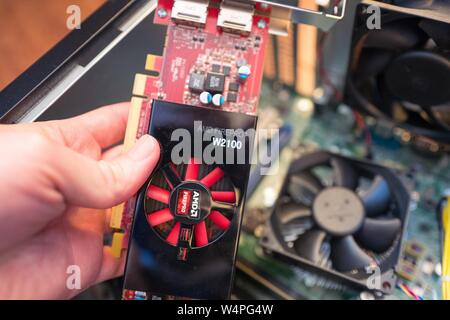 Einen Mann der Installation eines AMD Firepro Graphical Processing Unit (GPU), aka Grafikkarte in einem cryptocurrency Bergbau computer für den Bergbau die Bitcoin alternative Monero, San Ramon, Kalifornien, 29. August 2018. () Stockfoto