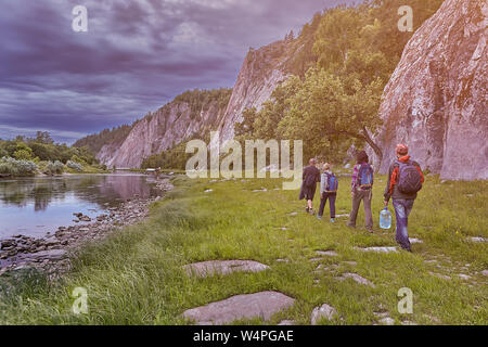 Ökotourismus, die Gruppe Wanderer zu Fuß auf den Weg entlang des Flusses, in einem wilden felsiges Gelände. Stockfoto