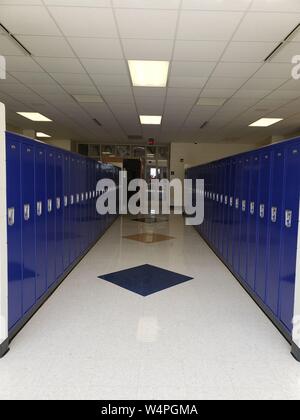 Eine Bank von blue Schüler Schließfächer in einem sauberen Middle School Hallway. Stockfoto