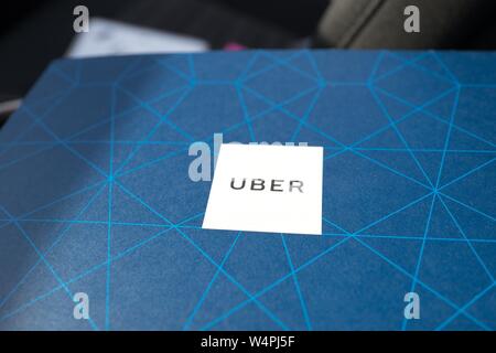 Close-up Logo für Uber auf die blau gedruckten Hintergrund einer Fahrer- handbuch um neue Treiber, ausgestellt von der crowdsourced taxi service Uber, in ein Uber Fahrzeug in San Ramon, Kalifornien, 27. September 2018. () Stockfoto