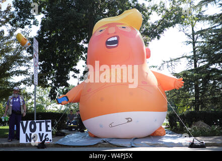 Mitglieder der Öffentlichkeit ein Donald Trump baby Ballon auf dem Display während einer Messe in Maplewood, New Jersey. Stockfoto