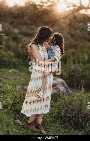 In voller Länge ansehen von Mutter und Tochter küssen im sonnigen Bereich Stockfoto