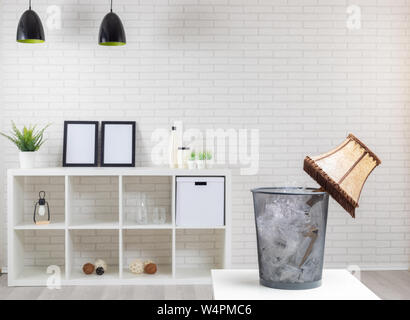 Flache Wiederaufbau/alte Lampe in den Mülleimer und neuen Möbeln im Hintergrund Stockfoto