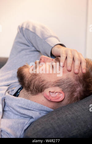 Ein junger Mann, sich krank fühlen, Leiter close-up, Seitenansicht. Stockfoto