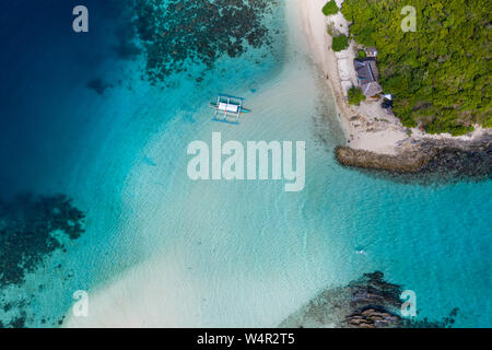 Luftaufnahme des Sandstrandes mit einem Boot, das in festgemacht ist Lagune, Port Barton, Palawan, Philippinen Stockfoto