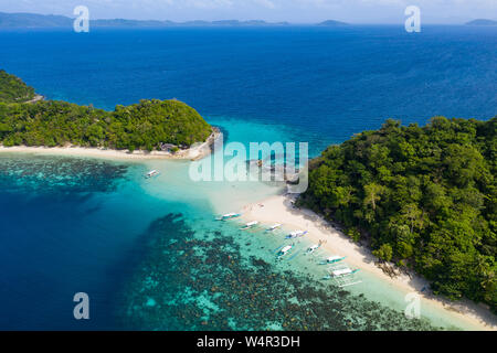 Luftbild von Auslegerbooten, die am Strand festgemacht sind Paradise Island, Port Barton, Palawan, Philippinen. Die Insel auf der linken Seite, almos Stockfoto