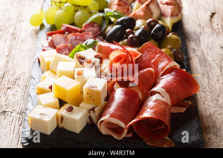 Mediterrane Snacks, Käseplatte, Schinken, Trauben, Feigen, Oliven, Würste und close-up. Horizontale Stockfoto