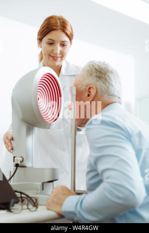 Arzt jedes Jahr. Nahaufnahme von Grauhaariger alter Mann Besuch Augenarzt in der privaten Klinik jedes Ohr Stockfoto