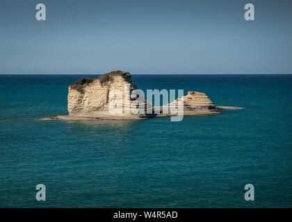 Felsen im Wasser in der Nähe der Küste, die zum Zeitpunkt des Sonnenaufgangs Stockfoto