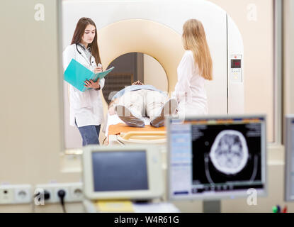 Mrt-Maschine und Bildschirme mit Arzt und Krankenschwester. Stockfoto