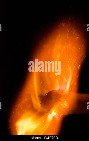 Entzündung von Streichholz mit Flammen vor dunklem Hintergrund, Stillleben Stockfoto