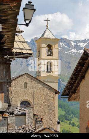 Traditionelle Holzhäuser und die Kirche in Saint Veran, mit der Bergkette im Hintergrund, im Regionalen Naturpark Queyras, Südliche Alpen, Frankreich Stockfoto