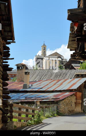 Traditionelle hölzerne Balkone und Dächer mit der Kirche im Hintergrund in Saint Veran Dorf, im Regionalen Naturpark Queyras, Südliche Alpen, Frankreich Stockfoto