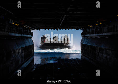 190724-N-BK 435-0109 CORAL SEA (Juli 24, 2019) - Landing Craft, Luftkissen (LCAC) 30, zugeordnet zu den Naval Beach (NBU) 7, tritt in das Deck des Amphibious Assault ship USS Wasp (LHD1). Wasp, Flaggschiff der Wasp Expeditionary Strike Group, mit 31 Marine Expeditionary Unit begonnen, nimmt derzeit an Talisman Sabre 2019 vor der Küste im Norden von Australien. Eine bilaterale, Biennale, Talisman Sabre ist für US-amerikanische und australische Combat Training, Bereitschaft und Interoperabilität durch realistische, entsprechende Schulungen notwendig, die regionale Sicherheit zu verbessern, Stockfoto