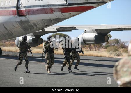 Botswana Defence Force Commandos Geiseln und Entführer von einem Flugzeug entfernen während einer Übung an Thebephatshwa Air Base in Botswana am 17. Juli 2019. Die übung war Teil eines zweitägigen Höhepunkt, eine simulierte Flugzeugentführung enthalten. Mehr als 170 des Heeres und der Wachposten aus North Carolina, Alabama und New Jersey in Zusammenarbeit mit ihren Kollegen in Botswana Defence Force Nach oben Minuteman2019, ein US Africa Command Übung zur Förderung der US-Nationalgarde Partnerschaft Programme auf dem Afrikanischen Kontinent ausgebildet. (U.S. Armee Foto: Staff Sgt. Maria Stockfoto