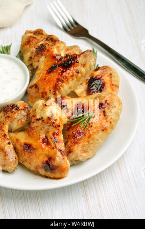 Vorspeise Chicken Wings mit Soße auf weiße Platte, Ansicht schließen Stockfoto