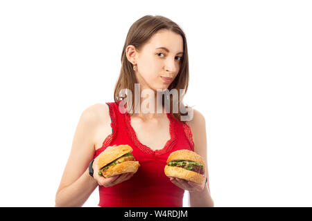 Glückliche junge Frau zeigen Hamburger auf weißem Hintergrund Stockfoto