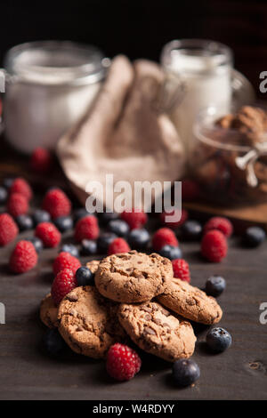 Nahaufnahme von köstlichen Haufen Schokolade Cookies mit dunkler Schokolade und frischen Himbeeren. Gesunde Kekse. Stockfoto