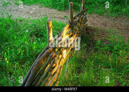 Ein Zaun aus Ästen am Abend gewebt, Russland Stockfoto