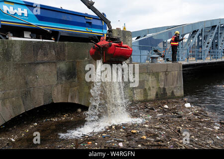 Reinigung von Ablagerungen an der Brücke gesammelt auf dem Wasser von Leith Fluss in Leith nach starken Regenfällen, Schottland, Großbritannien Stockfoto