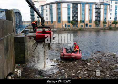 Reinigung von Ablagerungen an der Brücke gesammelt auf dem Wasser von Leith Fluss in Leith nach starken Regenfällen, Schottland, Großbritannien Stockfoto