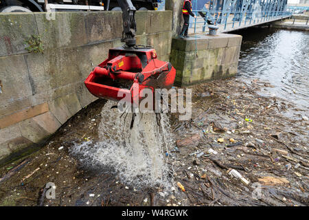 Reinigung von Ablagerungen an der Brücke gesammelt auf dem Wasser von Leith Fluss in Leith nach starken Regenfällen, Schottland, Großbritannien Stockfoto