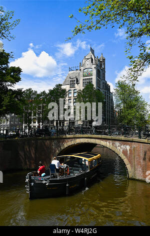 Tourboat vorbei unter Brücke, Amsterdam, Niederlande Stockfoto