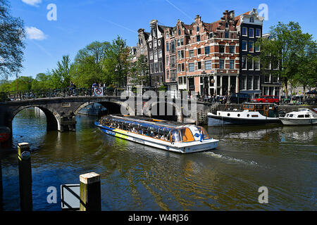 Tourboat vorbei unter Bogenbrücke, Amsterdam, Niederlande Stockfoto